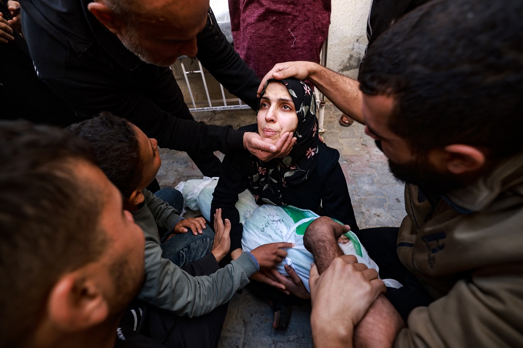 مواطنة تحتضن جثمان طفلها الشهيد في مستشفى الشهيد أبو يوسف النجار في رفح جنوب قطاع غزة (أ ف ب)