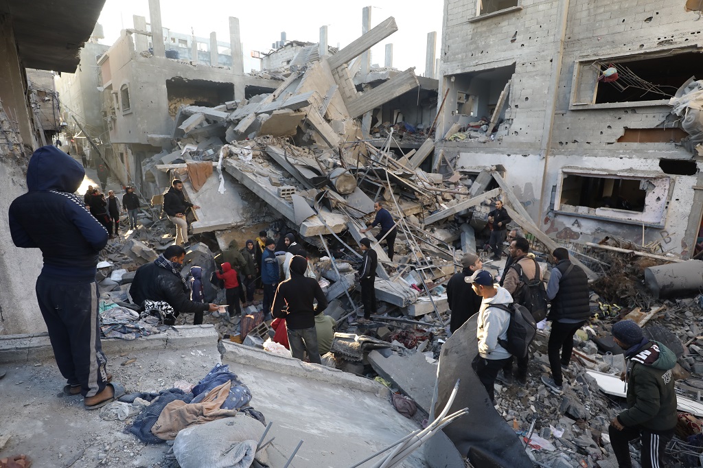 مواطنون يتفقدون آثار الدمار في منزل قصفته طائرات الاحتلال الإسرائيلي في مخيم البريج وسط قطاع غزة (الأناضول)