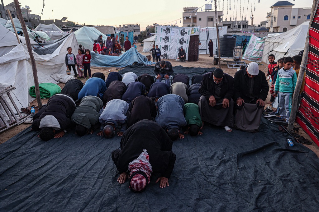 مواطنون يؤدون الصلاة في مخيم للنازحين في رفح جنوب قطاع غزة (أ ف ب)